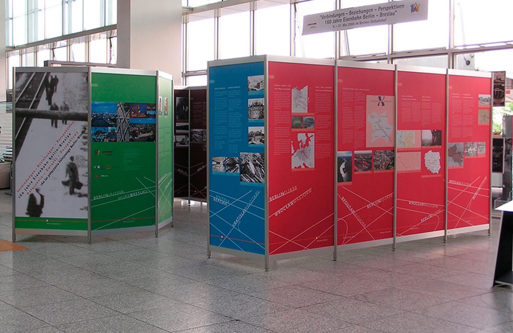Octanorm Messetafeln in rot, blau und grün stehen nebeneinander in einem Ausstellungsraum.