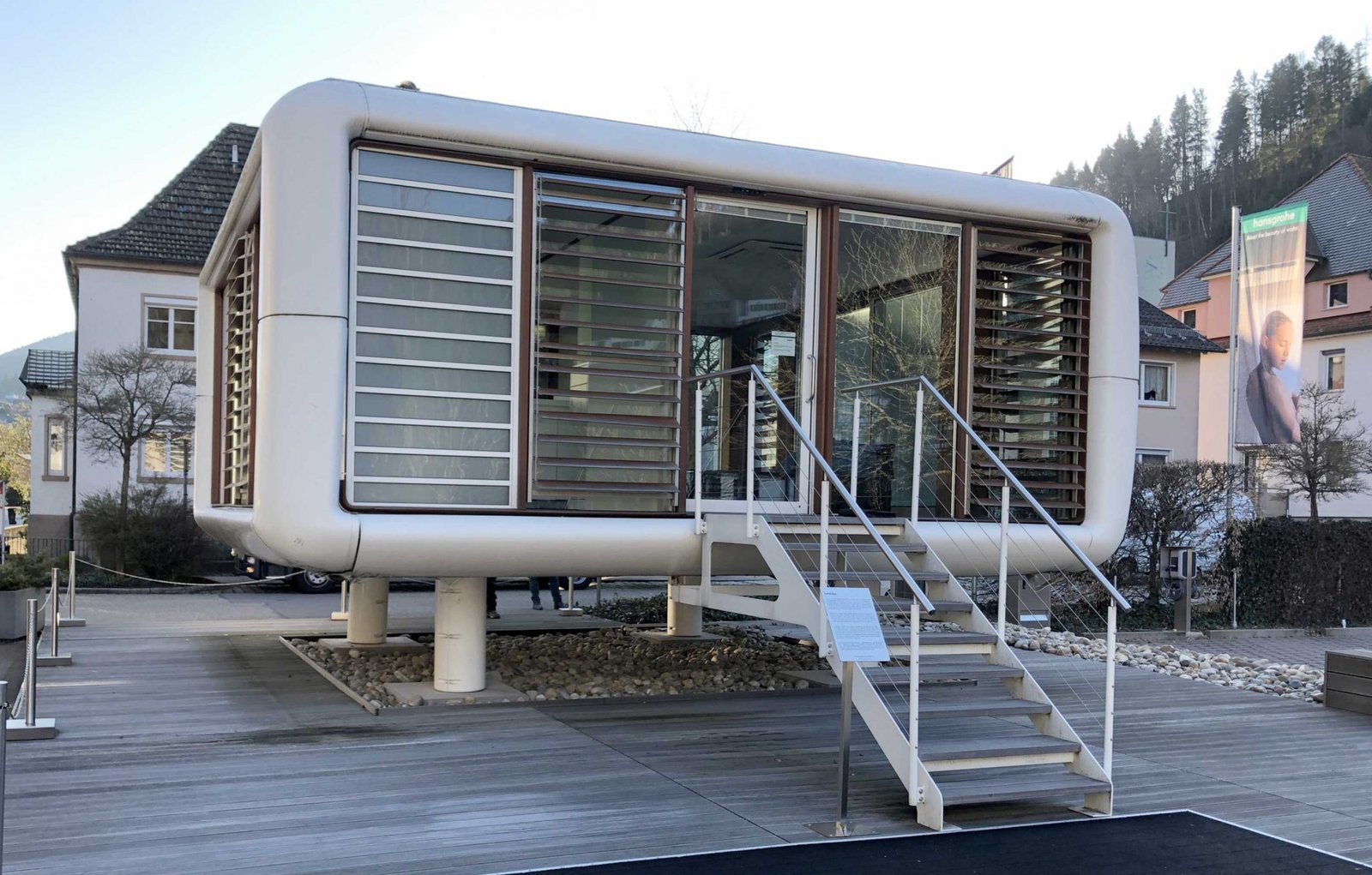 Ein futuristischer Präsentationsraum der Firma Hansgrohe, ein Pavillon auf Stelzen mit einer Freitreppe.