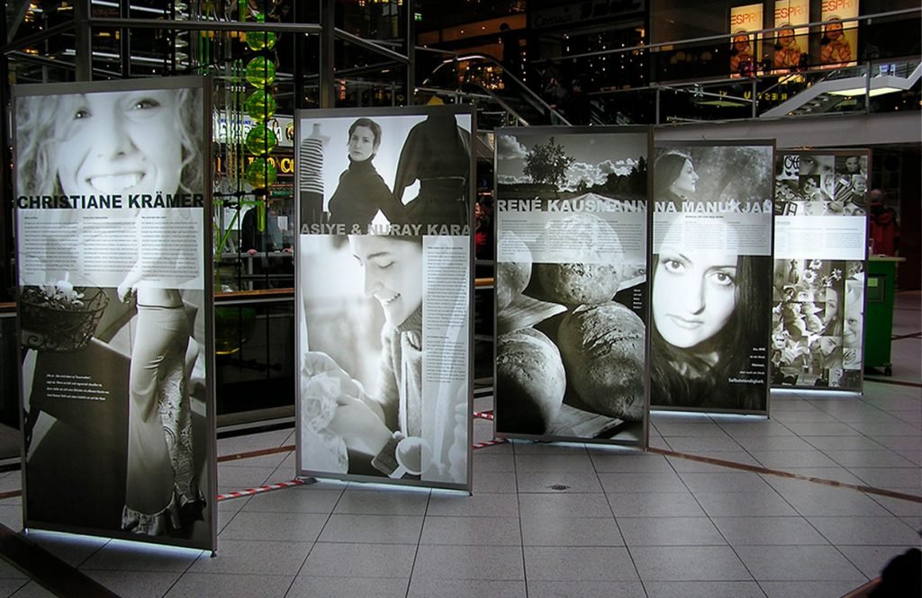 Octanorm Leuchttafeln sind mit schwarz-weiß Fotografien gestaltet und werden in einer Ausstellung genutzt.
